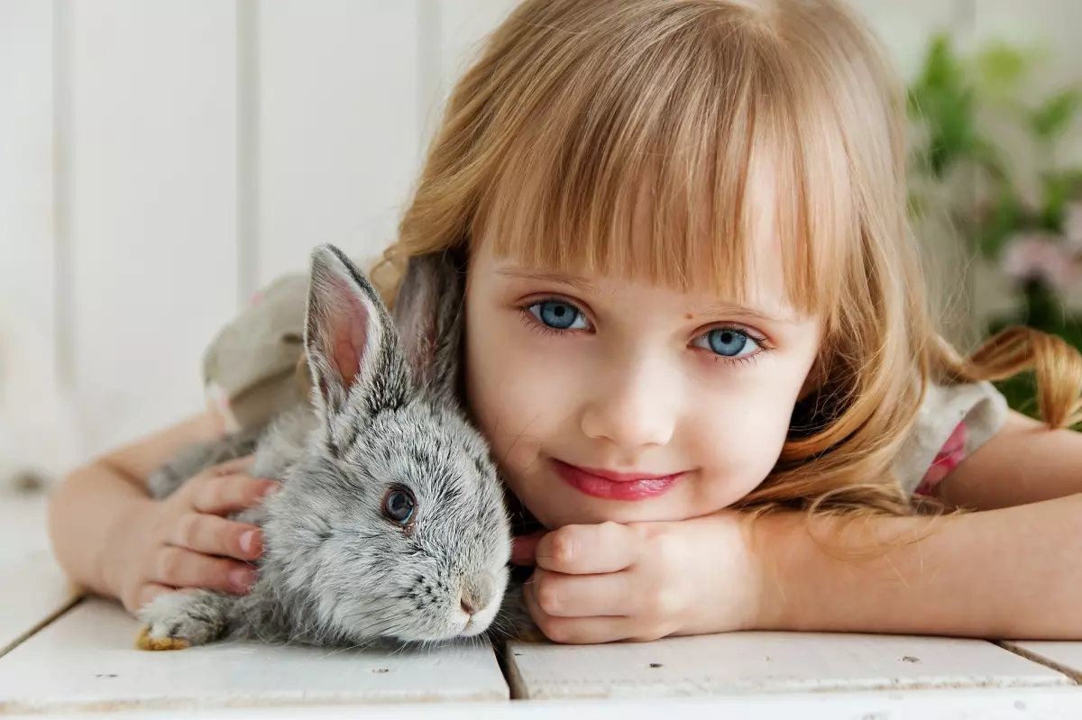 Partido Vegano - Niña acostada junto a un conejo - Asociación Española de Pediatría - Comer animales - Empatía infantil